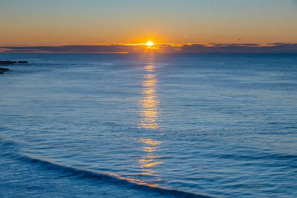 stock image Sunrise seascape with low cloud bank at Soldiers Beach located at Norah Head on the Central Coast, NSW, Australia.