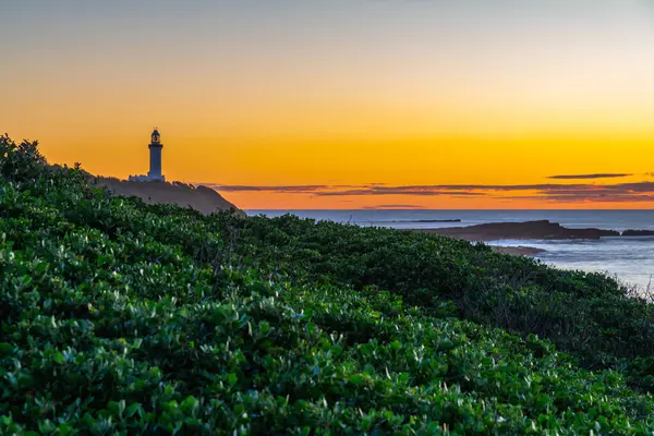 stock image Sunrise seascape with low cloud bank and Norah Head Lighthouse from Soldiers Beach on the Central Coast, NSW, Australia.