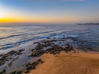 Hazy aerial sunrise over Spoon Bay in Wamberal Lagoon Nature Reserve on the Central Coast, NSW, Australia. clipart