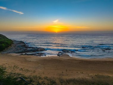 Hazy aerial sunrise over Spoon Bay in Wamberal Lagoon Nature Reserve on the Central Coast, NSW, Australia. clipart