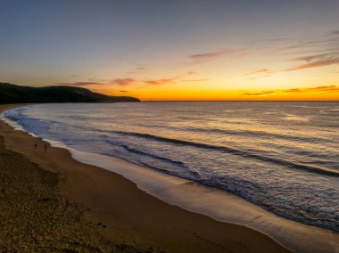 Pretty sunrise over the beach and ocean with high cloud at Killcare Beach on the Central Coast, NSW, Australia. clipart