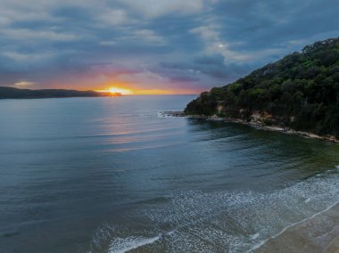 Yaz gündoğumu yağmur bulutlarıyla Orta Sahildeki Umina Sahili 'nde, NSW, Avustralya.