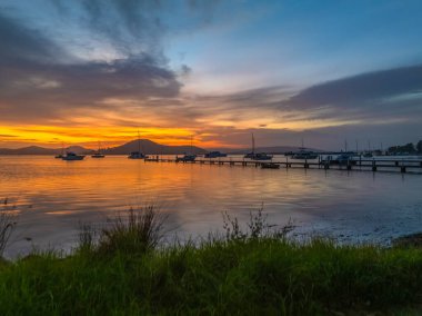 Subtle Sunrise with smoke haze and high cloud over Brisbane Water from Couche Park in Koolewong on the Central Coast, NSW, Australia. clipart