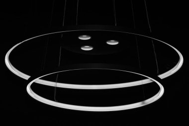 Karanlıkta tavandan sarkan daireler ve ışıklar.