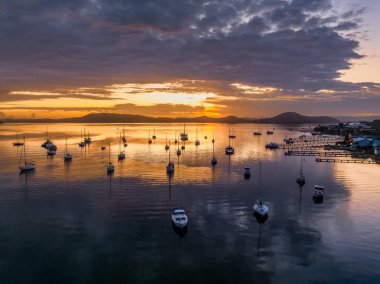 Sunrise and clouds over the boats on Brisbane Water at Koolewong and Tascott on the Central Coast, NSW, Australia. clipart