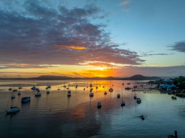 Gündoğumu ve bulutlar Brisbane 'deki teknelerin üzerinden Koolewong' da ve Tascott 'ta merkez sahilde, NSW, Avustralya' da.