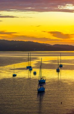 Gündoğumu ve bulutlar Brisbane 'deki teknelerin üzerinden Koolewong' da ve Tascott 'ta merkez sahilde, NSW, Avustralya' da.