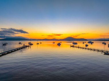 Botlarla, yansımalarla ve dağların etrafındaki hava güneşli su manzarası Orta Sahildeki Couche Park 'tan, NSW, Avustralya' daki Couche Park 'tan..