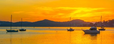 Botlarla, yansımalarla ve dağların etrafındaki hava güneşli su manzarası Orta Sahildeki Couche Park 'tan, NSW, Avustralya' daki Couche Park 'tan..