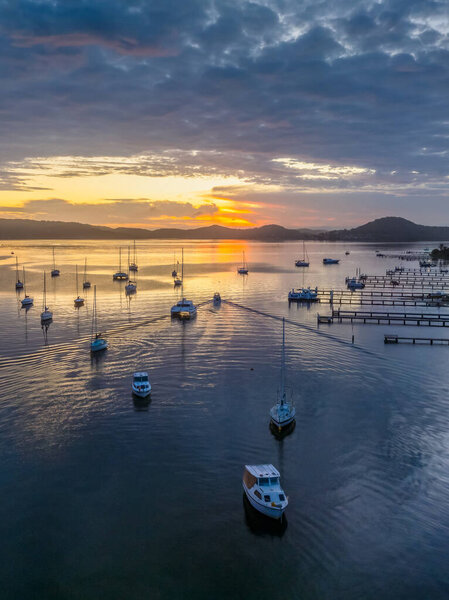 Восход солнца и облака над лодками на Брисбенской воде в Кулевонге и Таскотте на Центральном побережье штата Нью-Йорк, Австралия.