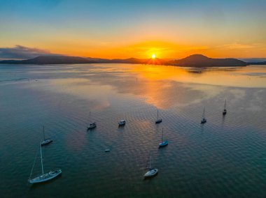 Botlarla, yansımalarla ve dağların etrafındaki hava güneşli su manzarası Orta Sahildeki Couche Park 'tan, NSW, Avustralya' daki Couche Park 'tan..