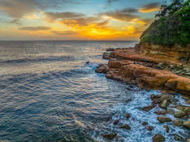 Central Coast, NSW, Avustralya 'daki Avoca Sahili' nde bulutlu ve sisli bir gün doğumu manzarası..