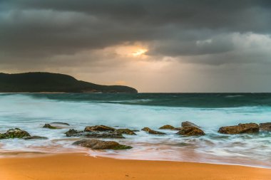 Windy and turbulent sunrise seascape with rain clouds at Killcare Beach on the Central Coast, NSW, Australia. clipart