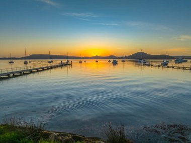 Brisbane Suyu üzerinde gün doğumu çoğunlukla açık gökyüzü ve Couche Park, Koolewong 'da hafif bulutlar Central Coast, NSW, Avustralya.
