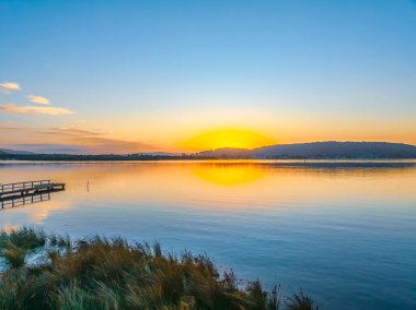 Brisbane Suyu 'nun üzerinde gün doğumu ve hafif bulutlar Orta Sahilde Woy Woy' da, NSW, Avustralya.