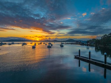 Brisbane 'de teknelerle gün doğumu ve bulutlar Koolewong' da ve Tascott 'ta merkez sahilde, NSW, Avustralya.