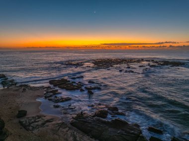 Norah Head, NSW, Avustralya 'daki asker plajından denizin üzerinde gün doğumu..