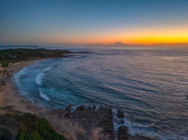 Aerial sunrise over the sea from Soldiers Beach at Norah Head, NSW, Australia. clipart