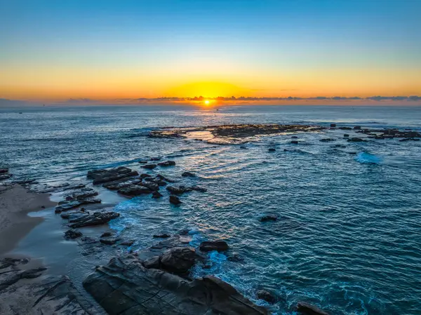 Norah Head, NSW, Avustralya 'daki asker plajından denizin üzerinde gün doğumu..