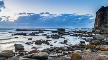 Autumn sunrise seascape with clouds and rocks at The Skillion in Terrigal, NSW, Australia. clipart