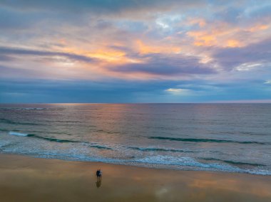Büyük Newcastle 'daki Swansea Yarımadası' ndaki Caves Beach 'te bulutlu bir gökyüzü ile deniz kenarında gün doğumu. Mağara Sahili, Avustralya 'nın NSW bölgesinin Hunter-Central Coast bölgesinde yer almaktadır..