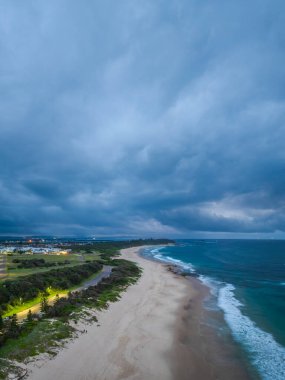 Sunrise at the seaside with cloud filled sky at Caves Beach on the Swansea peninsula in Greater Newcastle. Caves Beach is located in the Hunter-Central Coast Region of NSW, Australia. clipart