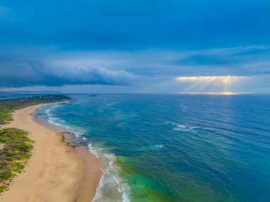 Büyük Newcastle 'daki Swansea Yarımadası' ndaki Caves Beach 'te bulutlu bir gökyüzü ile deniz kenarında gün doğumu. Mağara Sahili, Avustralya 'nın NSW bölgesinin Hunter-Central Coast bölgesinde yer almaktadır..