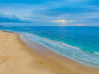 Büyük Newcastle 'daki Swansea Yarımadası' ndaki Caves Beach 'te bulutlu bir gökyüzü ile deniz kenarında gün doğumu. Mağara Sahili, Avustralya 'nın NSW bölgesinin Hunter-Central Coast bölgesinde yer almaktadır..
