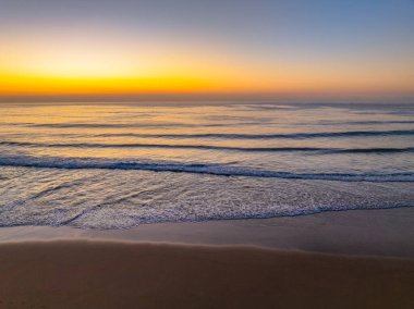 Gündoğumu deniz manzarası. Shelly Sahili 'nde açık bir gökyüzü var. Central Coast, NSW, Avustralya..