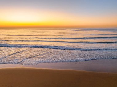 Gündoğumu deniz manzarası. Shelly Sahili 'nde açık bir gökyüzü var. Central Coast, NSW, Avustralya..
