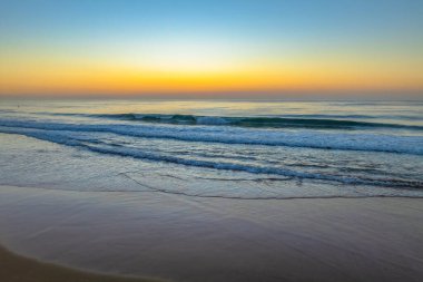 Gündoğumu deniz manzarası. Shelly Sahili 'nde açık bir gökyüzü var. Central Coast, NSW, Avustralya..