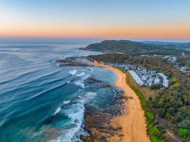 Gündoğumu deniz manzarası. Shelly Sahili 'nde açık bir gökyüzü var. Central Coast, NSW, Avustralya..