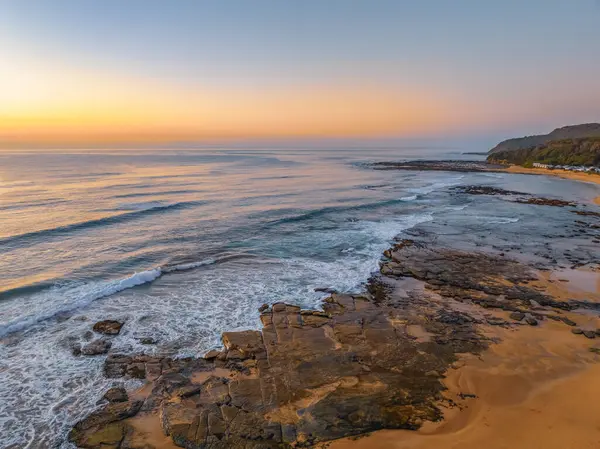 Gündoğumu deniz manzarası. Shelly Sahili 'nde açık bir gökyüzü var. Central Coast, NSW, Avustralya..