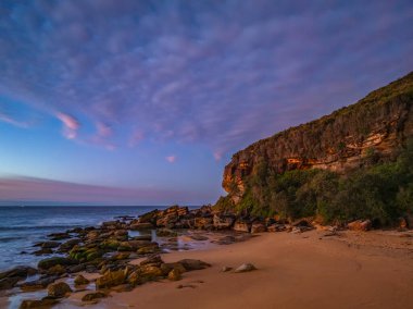 Gündoğumu deniz manzarası. Yüksek ve orta büyüklükteki bulutların karışımı. Killcare Sahili üzerinde güzel bir gökyüzü..