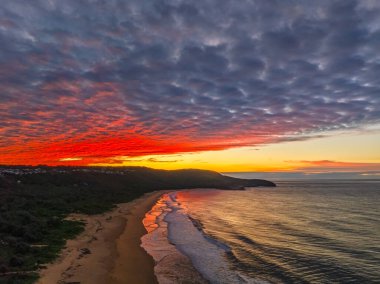Gündoğumu deniz manzarası. Yüksek ve orta büyüklükteki bulutların karışımı. Killcare Sahili üzerinde güzel bir gökyüzü..