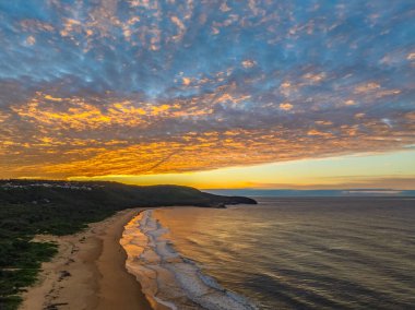 Gündoğumu deniz manzarası. Yüksek ve orta büyüklükteki bulutların karışımı. Killcare Sahili üzerinde güzel bir gökyüzü..