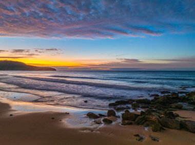 Gündoğumu deniz manzarası. Yüksek ve orta büyüklükteki bulutların karışımı. Killcare Sahili üzerinde güzel bir gökyüzü..