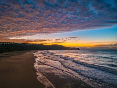 Gündoğumu deniz manzarası. Yüksek ve orta büyüklükteki bulutların karışımı. Killcare Sahili üzerinde güzel bir gökyüzü..