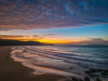 Gündoğumu deniz manzarası. Yüksek ve orta büyüklükteki bulutların karışımı. Killcare Sahili üzerinde güzel bir gökyüzü..