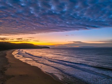 Gündoğumu deniz manzarası. Yüksek ve orta büyüklükteki bulutların karışımı. Killcare Sahili üzerinde güzel bir gökyüzü..