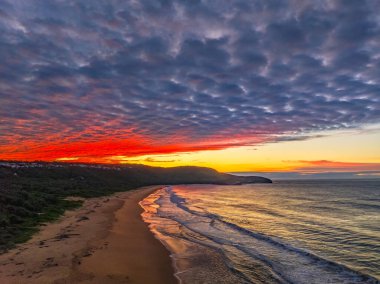 Gündoğumu deniz manzarası. Yüksek ve orta büyüklükteki bulutların karışımı. Killcare Sahili üzerinde güzel bir gökyüzü..