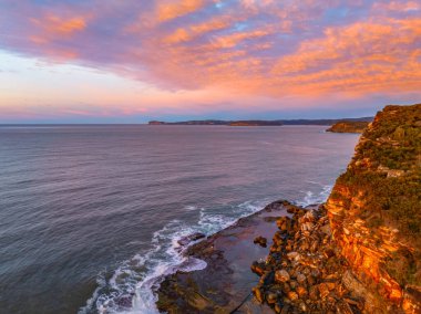 Gündoğumu deniz manzarası. Yüksek ve orta büyüklükteki bulutların karışımı. Killcare Sahili üzerinde güzel bir gökyüzü..