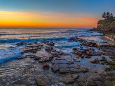 Sunrise Seascape with rocks and waves at Avalon on the Northern Beaches of Sydney, NSW, Australia. clipart