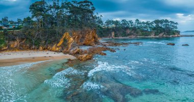 Denhams Sahili 'nde bulutlarla kaplı gündoğumu deniz manzarası, Avustralya' nın NSW 'nin güney kıyısında BatemansBay.