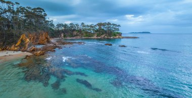 Denhams Sahili 'nde bulutlarla kaplı güneş doğuşu deniz manzarası, Avustralya' nın NSW 'nin güney kıyısında BatemansBay.