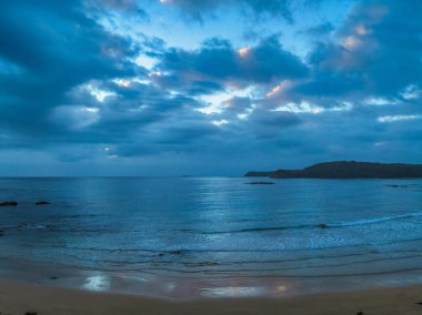 Denhams Sahili 'nde bulutlarla kaplı gündoğumu deniz manzarası, Avustralya' nın NSW 'nin güney kıyısında BatemansBay.