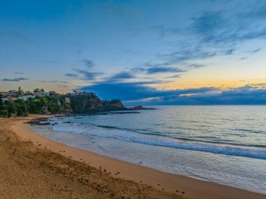 Avustralya 'nın NSW' nin güney kıyısındaki Malua Körfezi 'ne doğru ilerleyen yağmur bulutlarıyla birlikte gün doğumu denizi.