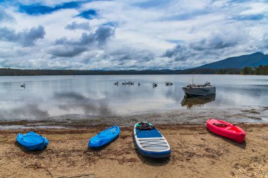 A hint of blue sky as the rain moves on at Wallaga Lake, Bermagui on the Sapphire Coast of NSW, Australia. clipart