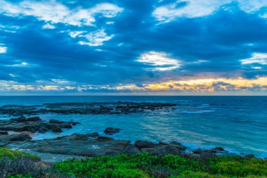 Norah Head, NSW, Avustralya 'daki Asker Sahili' nden denizin üzerinde rüzgarlı bir gün doğumu.