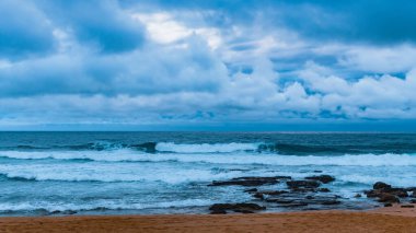 Sydney, NSW, Avustralya 'nın kuzey sahillerindeki Avalon' da kayalar ve dalgalarla kaplı Sunrise Seascape bulutları.